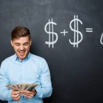 handsome man standing over blackboard  with drawn dollar concept